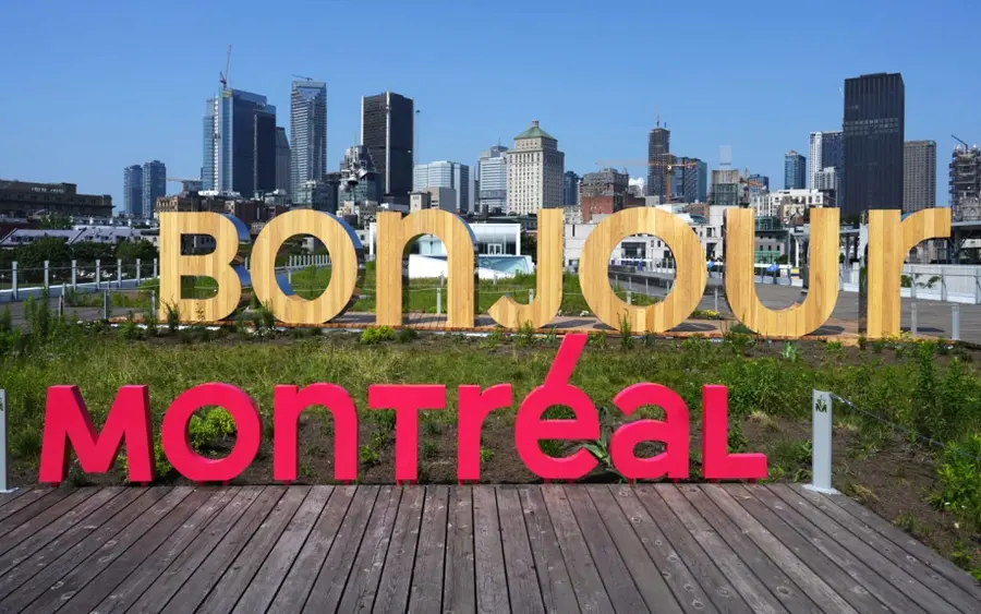 Bonjour Montréal sign with the city skyline behind it.