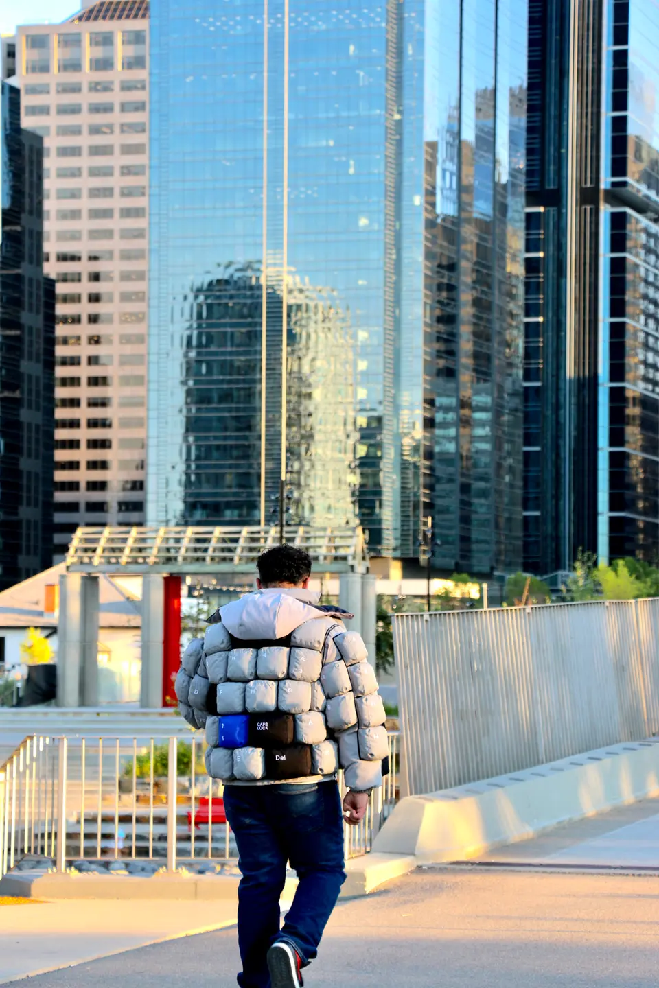 Walking toward a glass office tower.